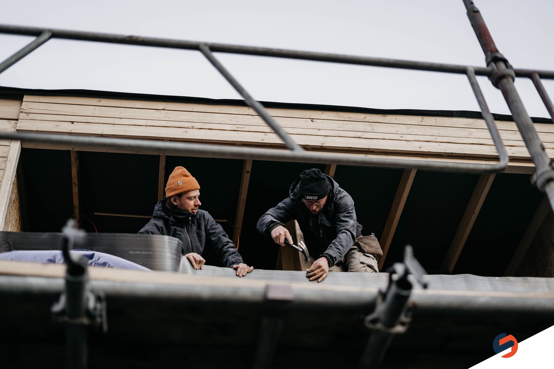 Twee mannen werken op het dak van een gebouw.