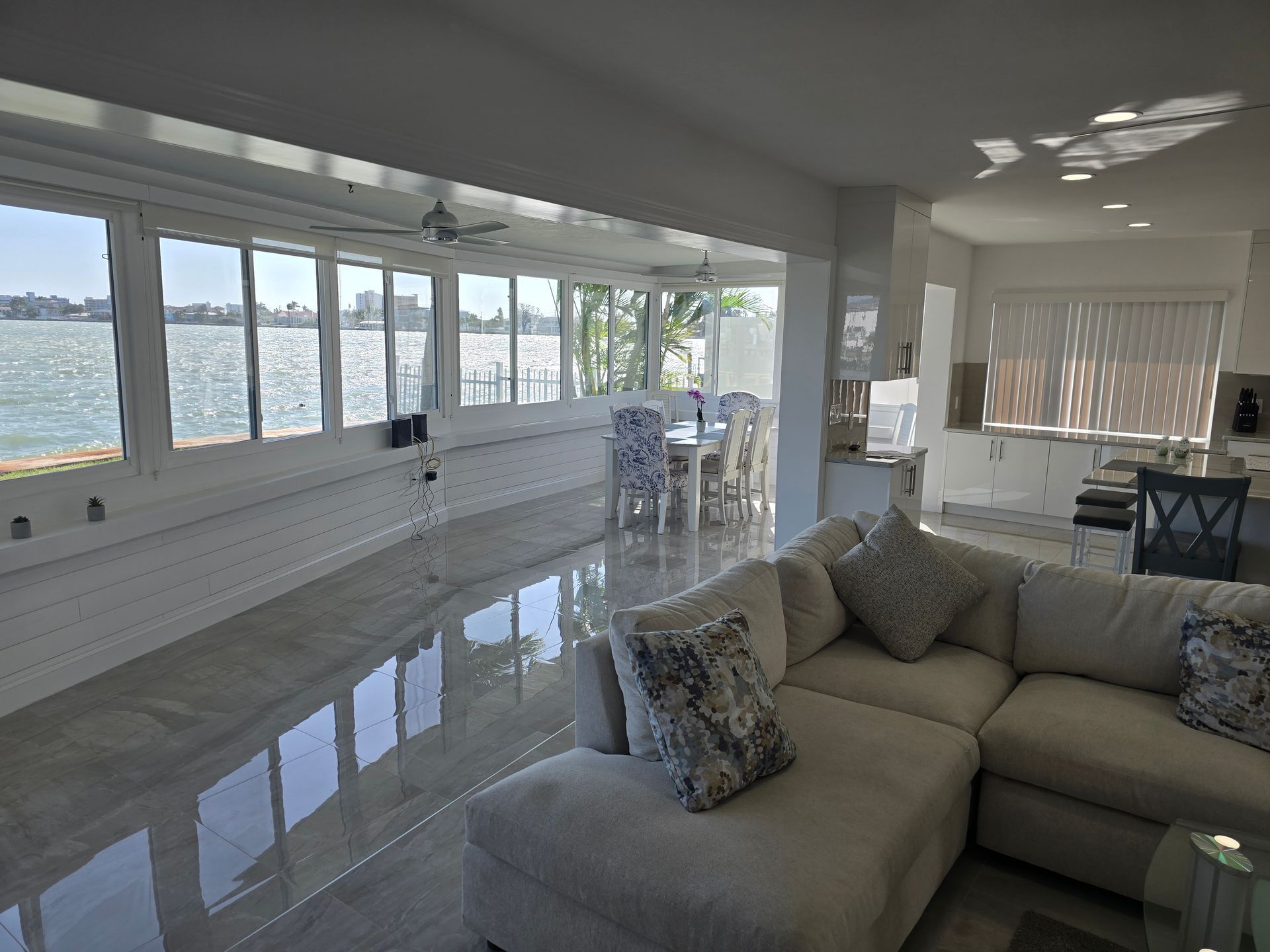 Bright living room with ocean views, tiled floor, and beige sectional sofa