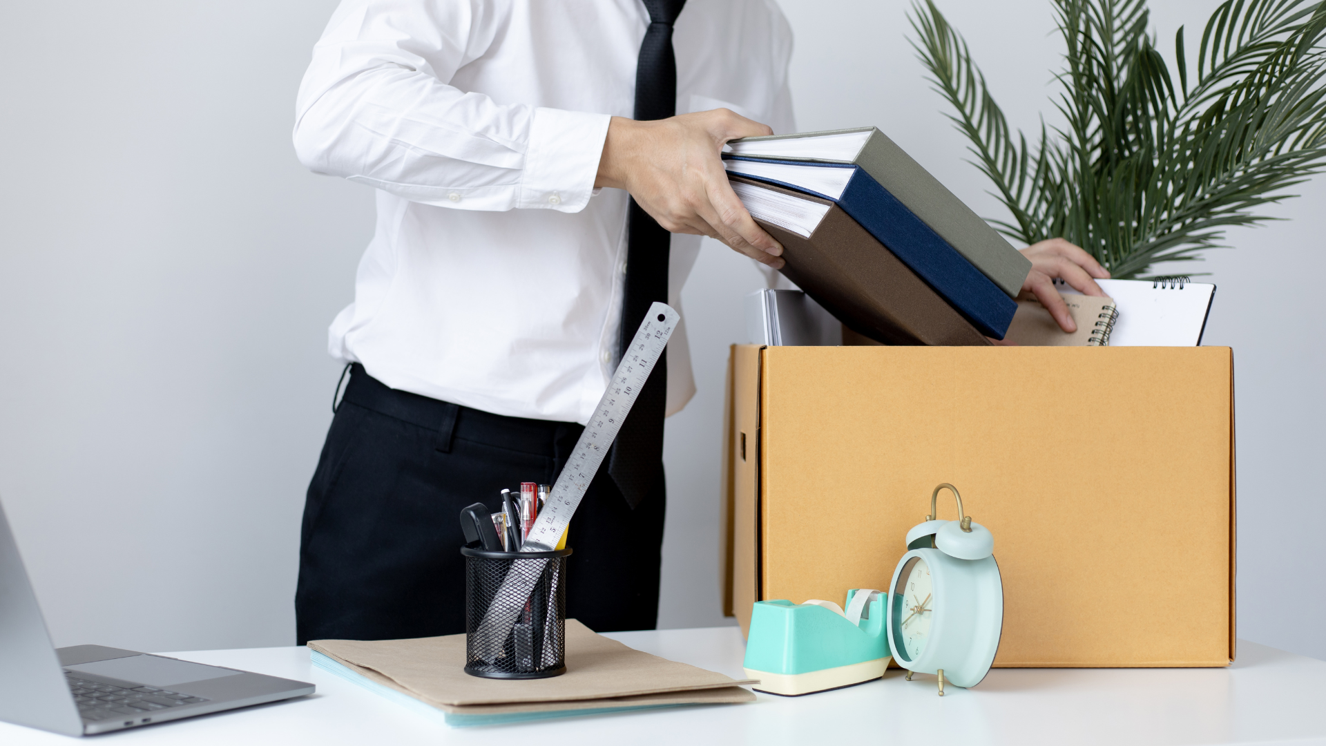 Business professional organizing office supplies and documents during a workspace transition