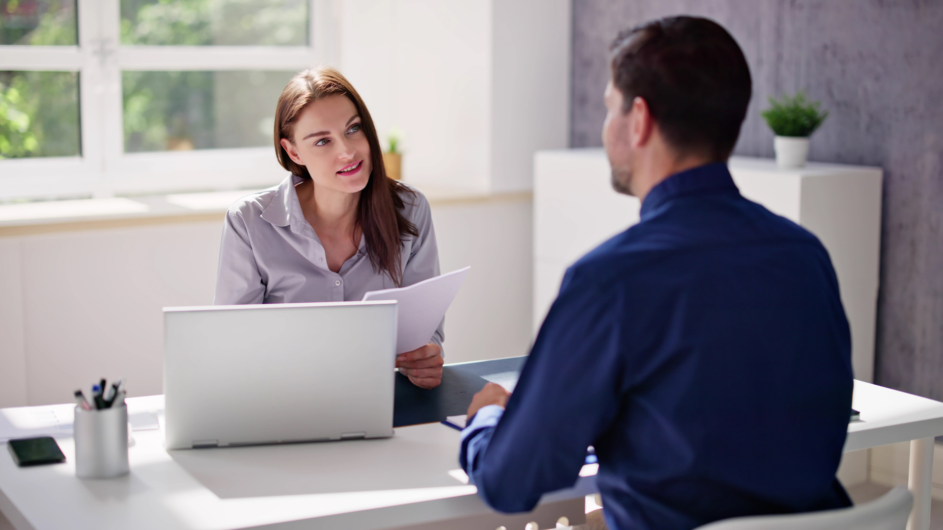 Business consultant advising a client during a professional office meeting