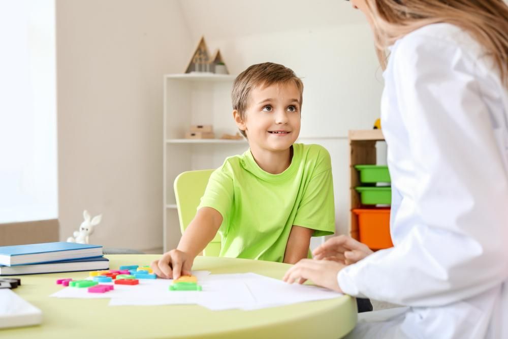 A Boy Sitting at A Table Talking to A Doctor — Oracle Psychology Child & Adolescent Psychologists Newcastle in Newcastle, NSW