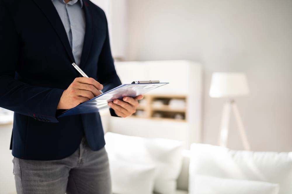 Person in Navy Blazer Writing on a Clipboard in a Bright Living Room — Oracle Psychology Child & Adolescent Psychologists Newcastle in Newcastle, NSW