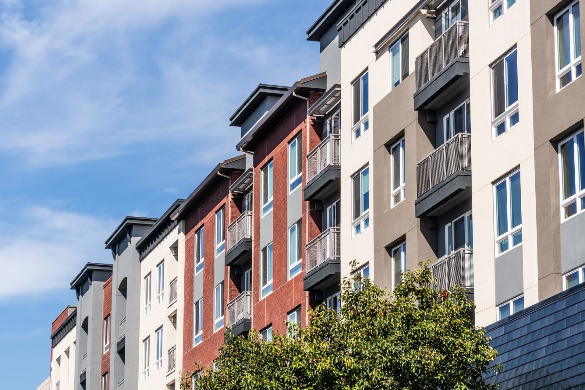 A row of apartment buildings with balconies on a sunny day.