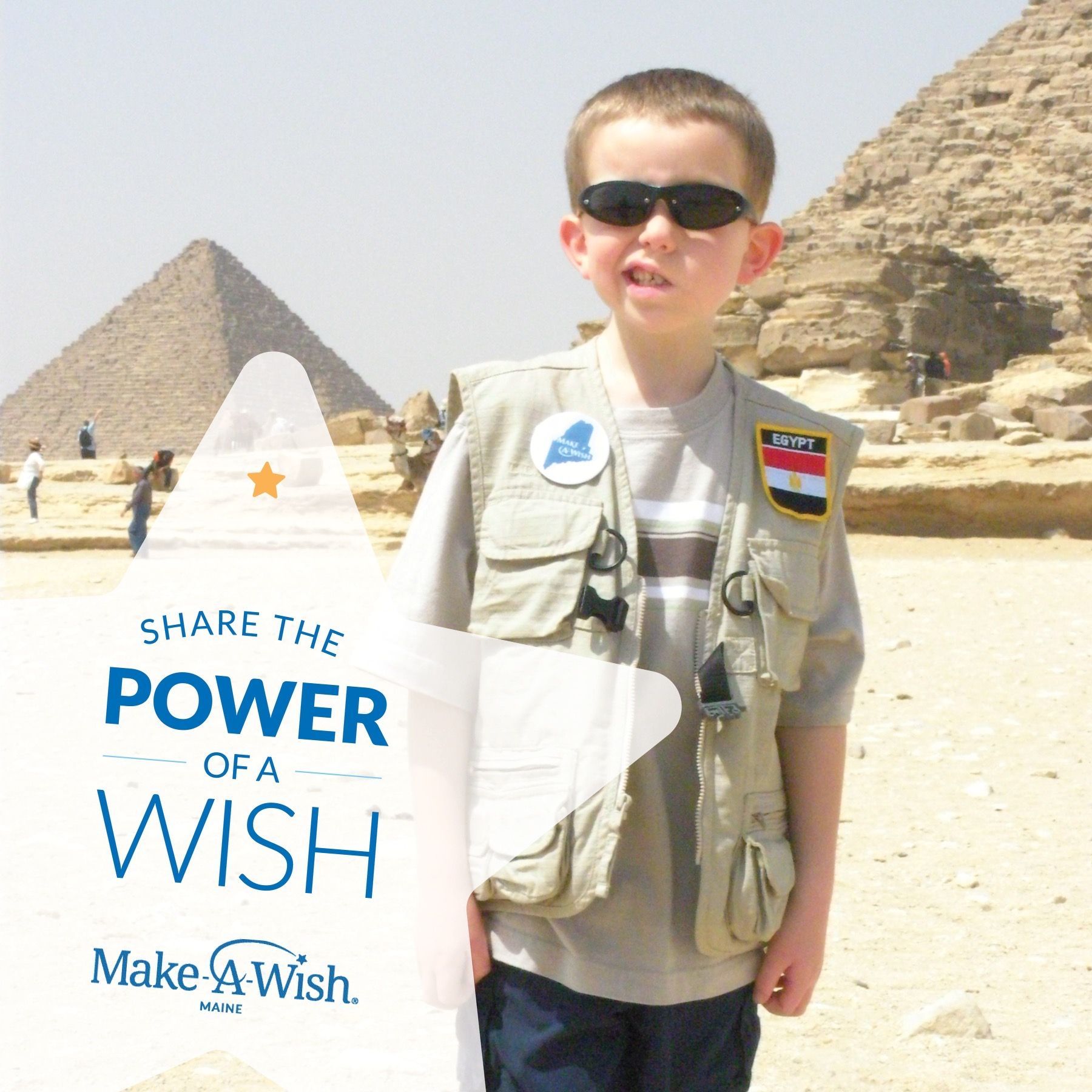A boy holding a sign that says share the power of a wish