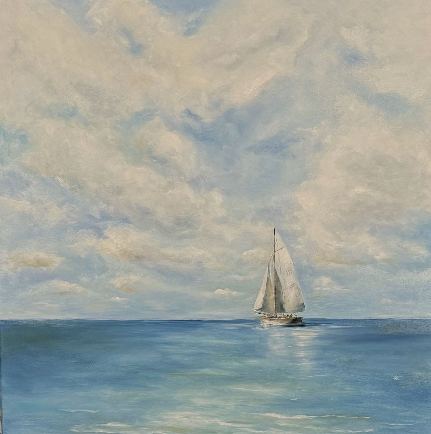 Sailboat on a calm blue sea under a cloudy sky