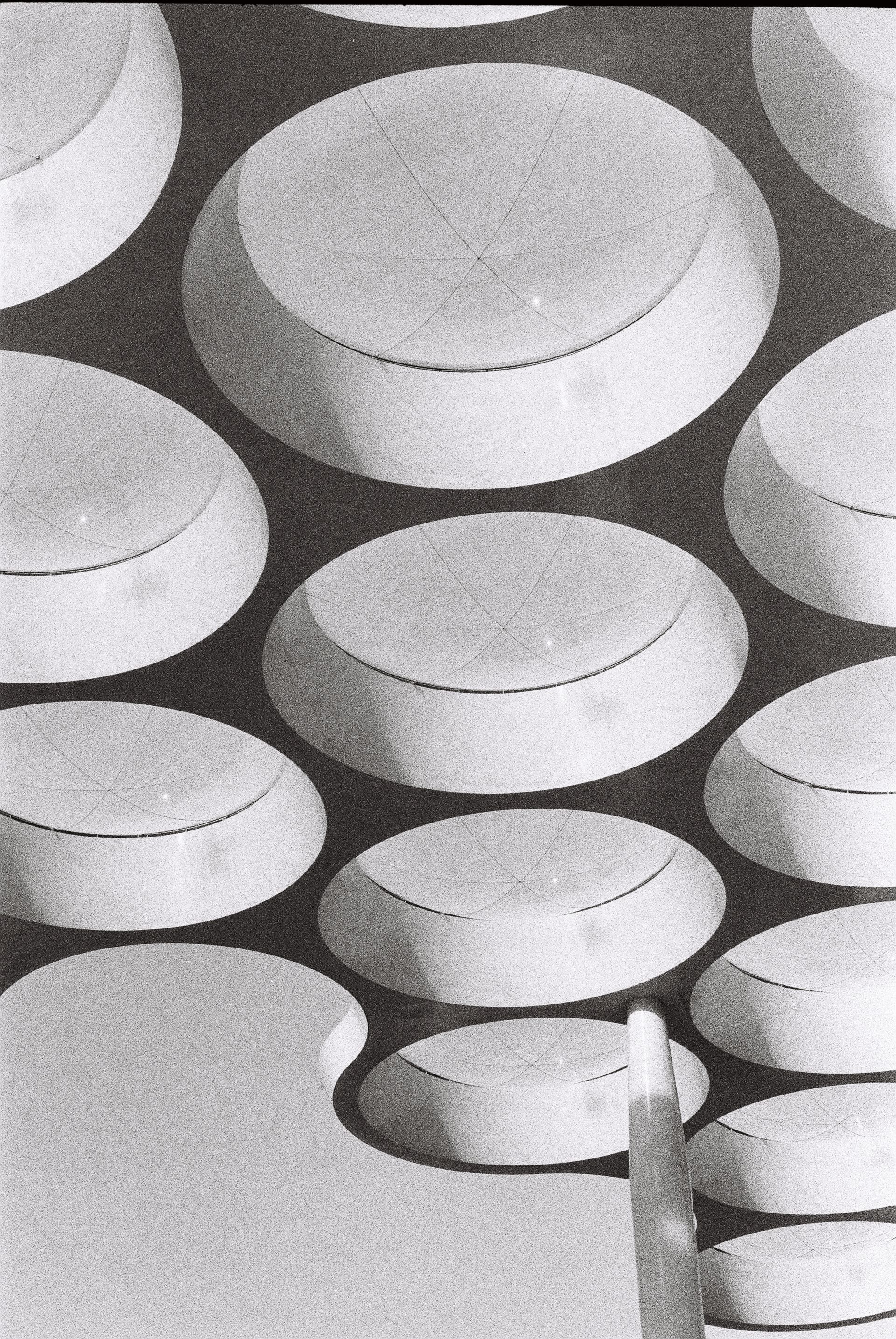Abstract black-and-white pattern of overlapping circular discs on a textured surface