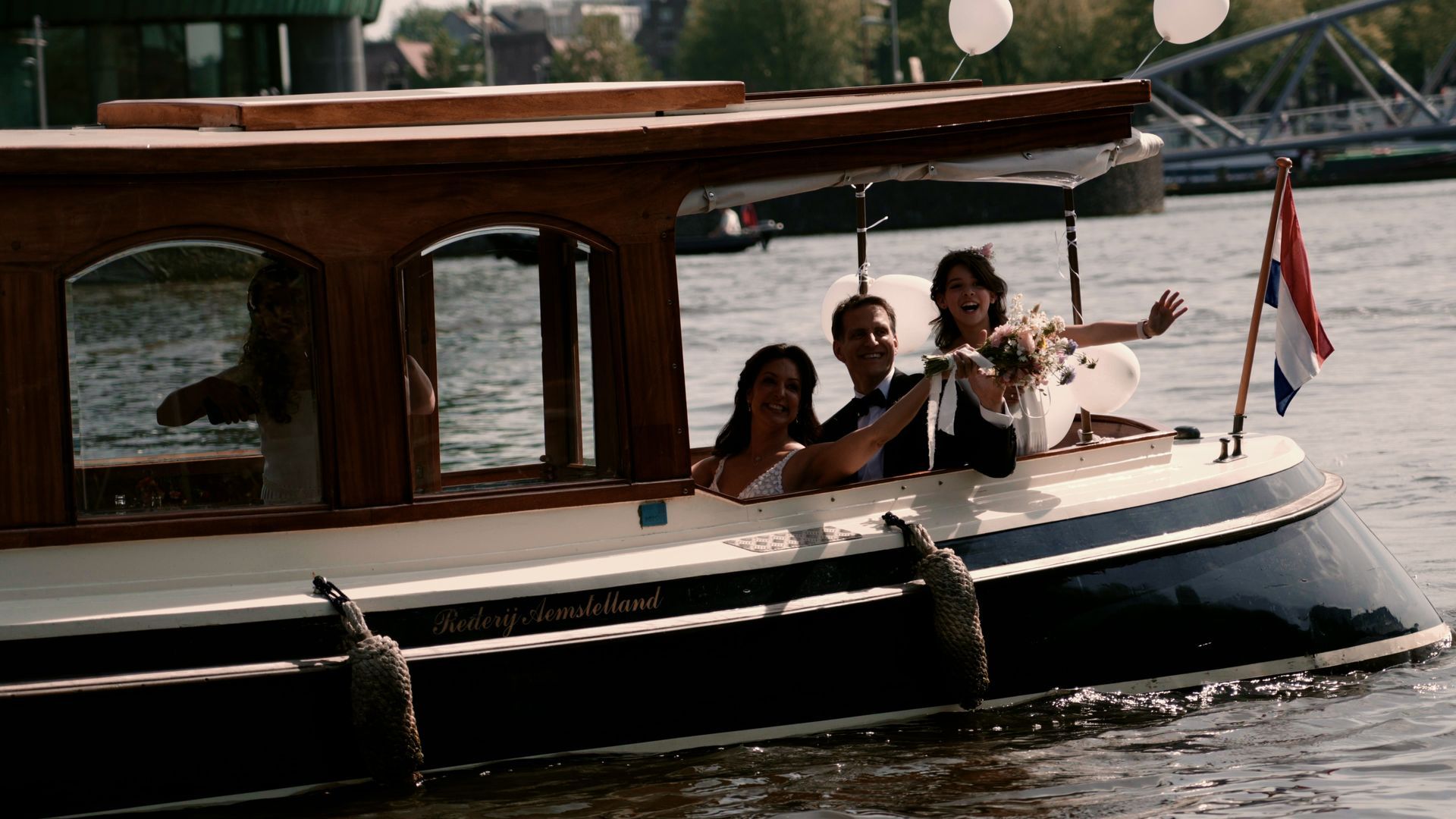 Wooden cabin cruiser on the water with three passengers relaxing on deck