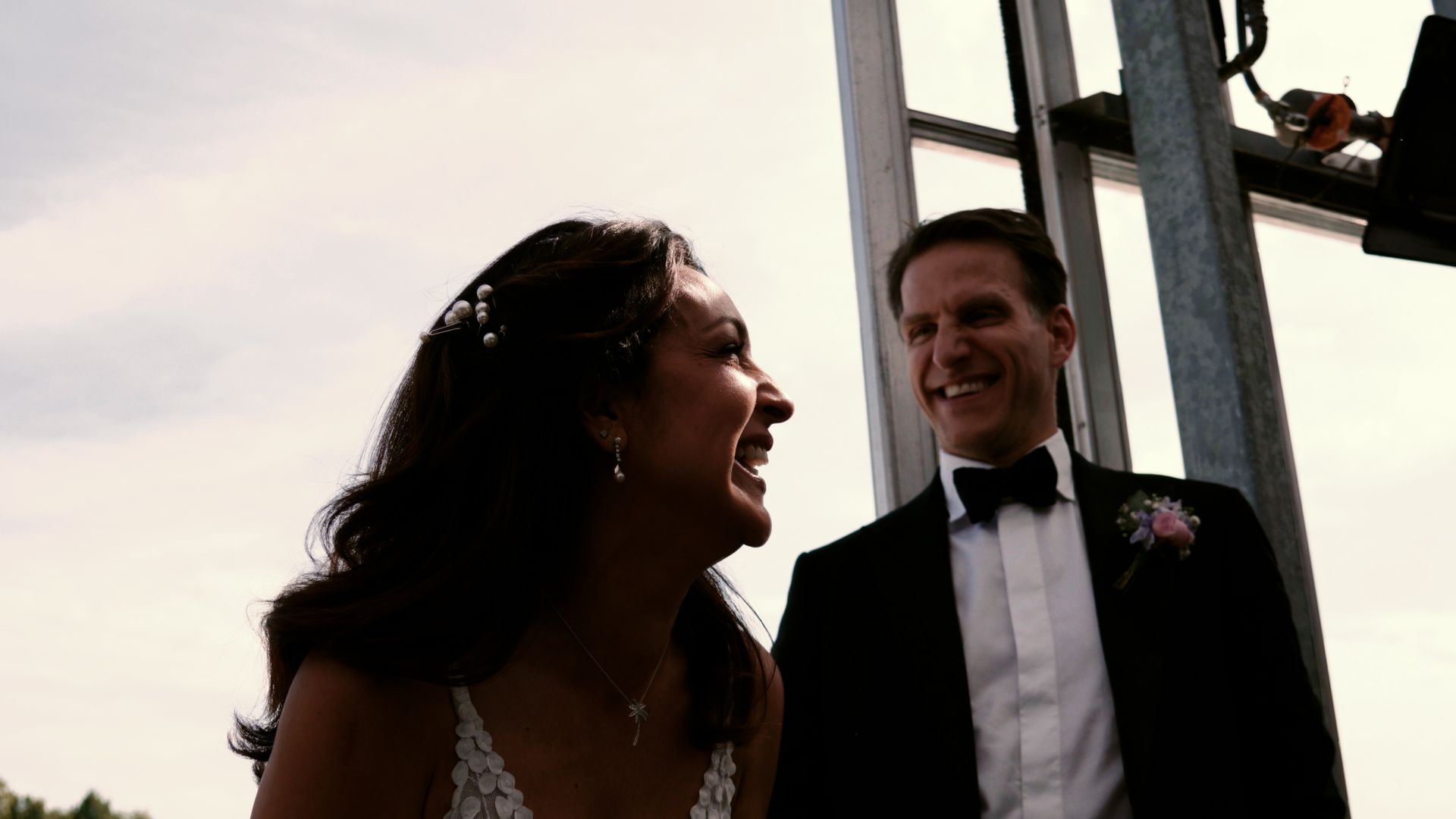 Bride and groom smiling at an outdoor wedding ceremony at sunset