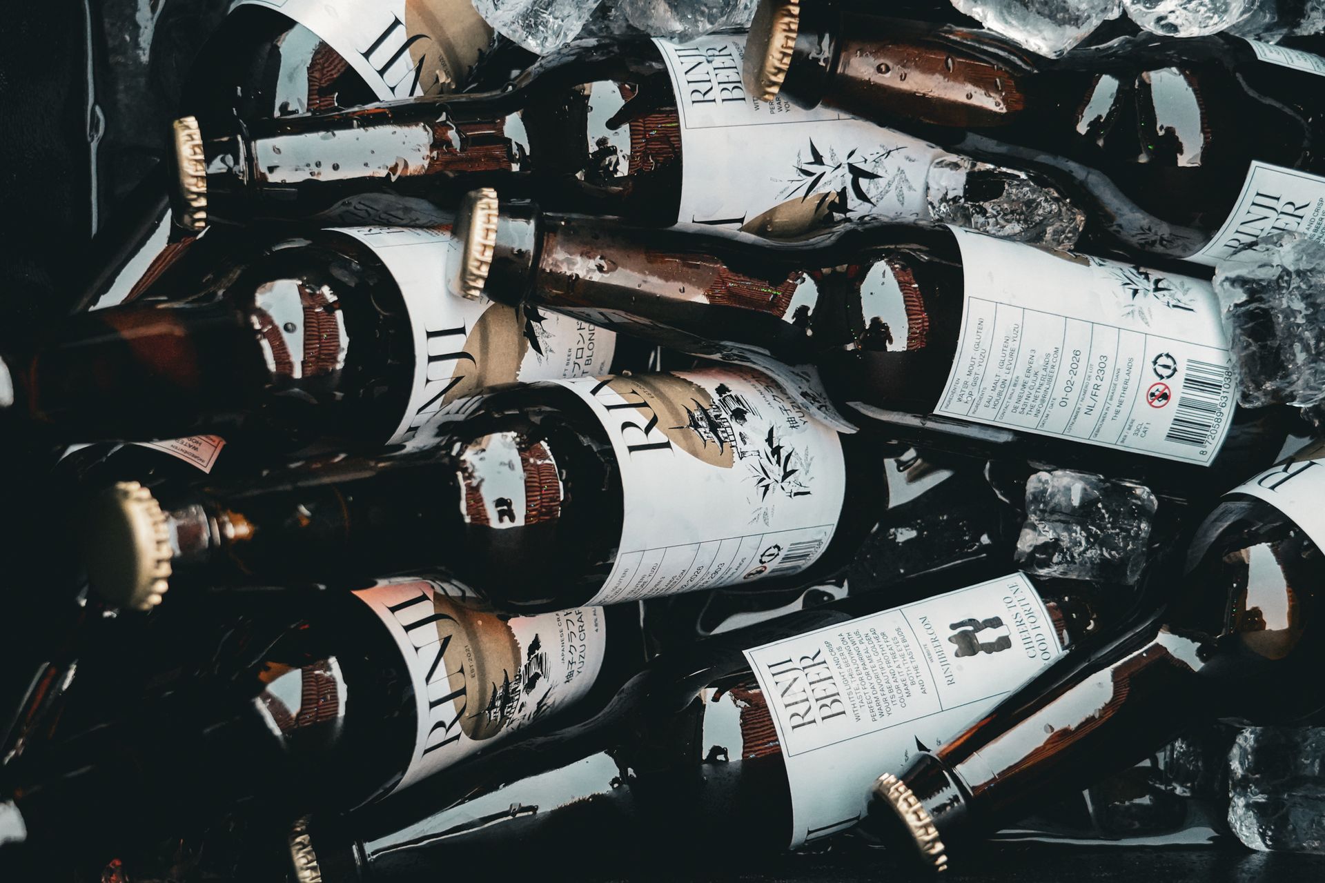 Stacked white wine bottles with dark labels and gold foil tops in a dim cellar