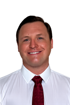 A man wearing glasses and a white shirt is smiling for the camera.