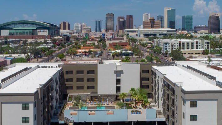 An aerial view of a city with a large building in the foreground, Photo by Phoenix Drone Pros, Robert Biggs
