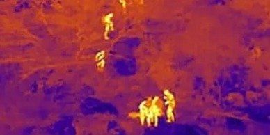 An aerial view of a group of people standing on top of a hill.