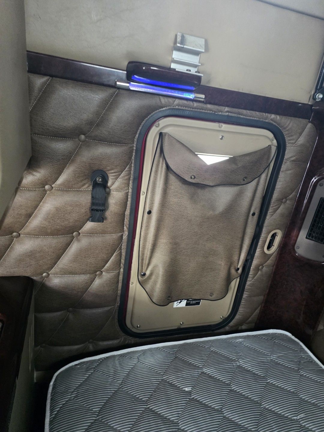 Quilted leather wall and bunk inside a semi truck sleeper cab in Largo, FL, before leather cleaning