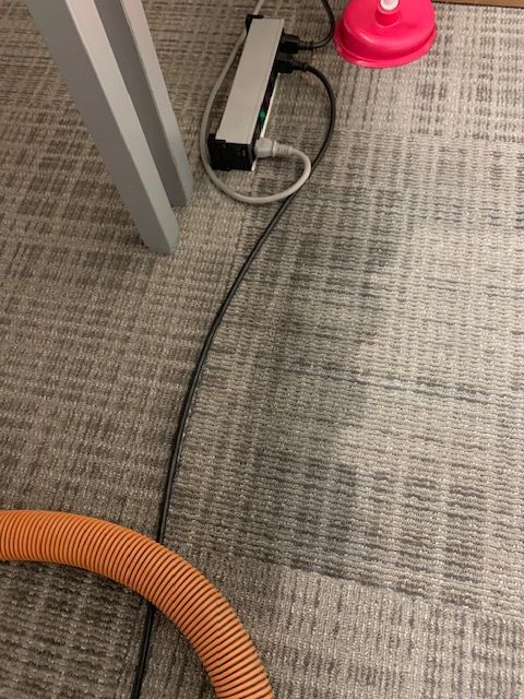 Toner explosion staining commercial office carpet around copier machine before cleaning