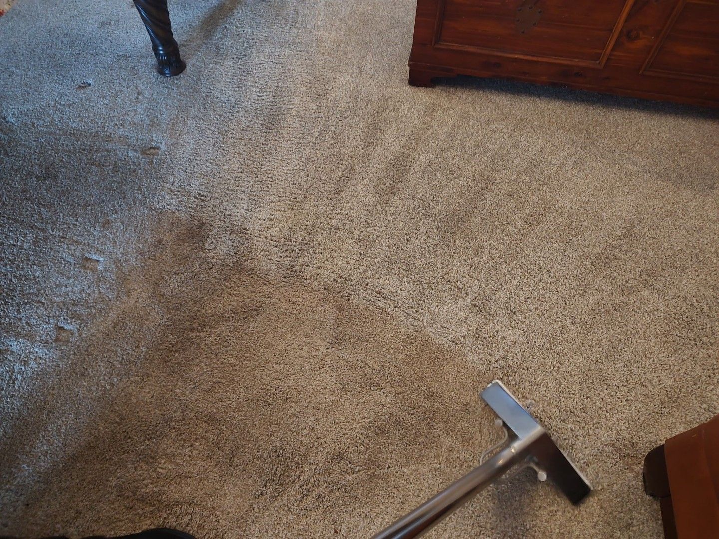 Cleaning wand running an extraction path through soiled hallway carpet during professional cleaning