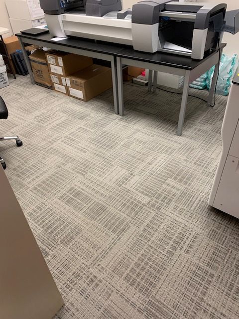 Clean and restored office carpet surrounding copier machine after toner spill removal
