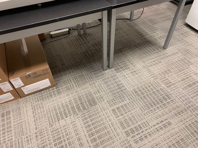 Fully restored commercial carpet under copier and adjacent desk after professional cleaning