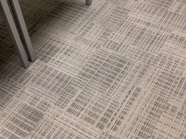 Clean carpet fibers between office desk legs after toner stain removal