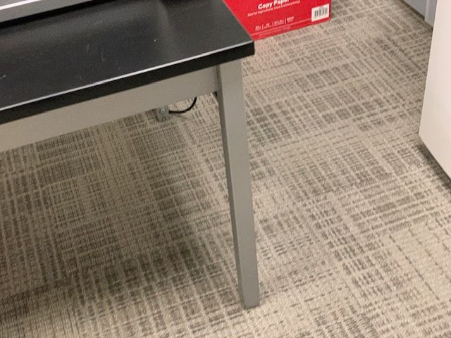 Clean carpet fibers around office desk leg after professional commercial cleaning