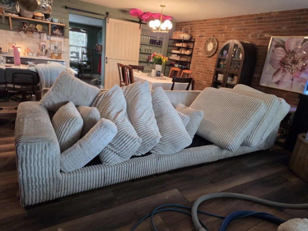 White sofa cushions stacked and staged for individual upholstery cleaning treatment