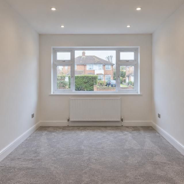 After: Inside a garage before conversion and after it became a carpeted, plastered room