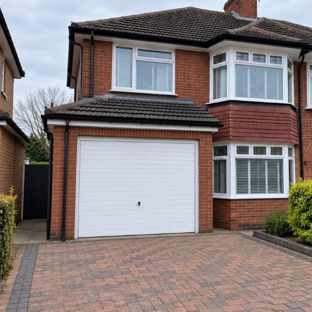 Before: Semi-detached house where the garage door has been replaced with brickwork and a window