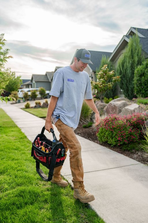 Owner of Flow State Plumbing walking into a customers home to repair plumbing.