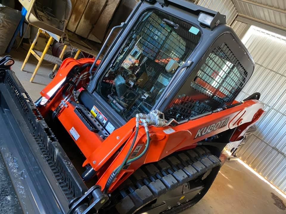 Orange and Black Kubota Track Skid Steer Loader in a Garage — Huntlys Heavy Equipment in Gracemere, QLD