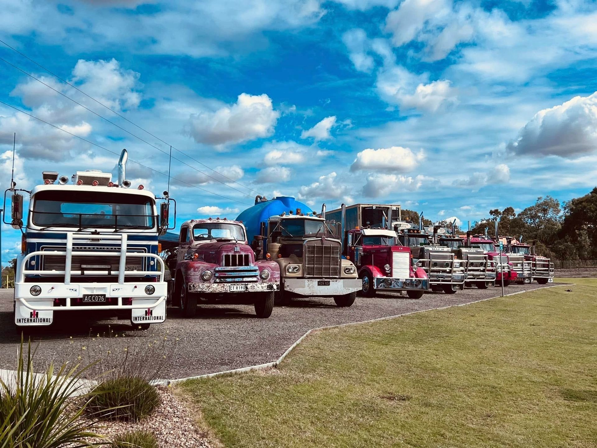 Line of Trucks Parked on Gravel, Under a Blue Sky With Clouds — Huntlys Heavy Equipment in Gracemere, QLD