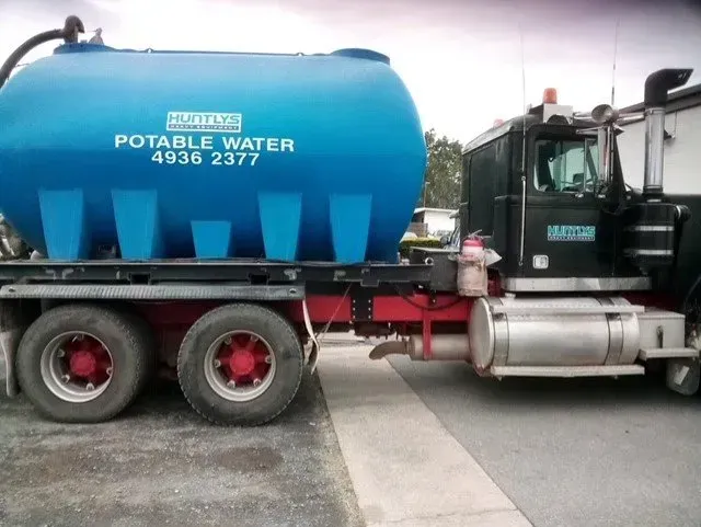 Blue Potable Water Tank on a Semi-truck Parked on a Paved Road — Huntlys Heavy Equipment In Gracemere, QLD