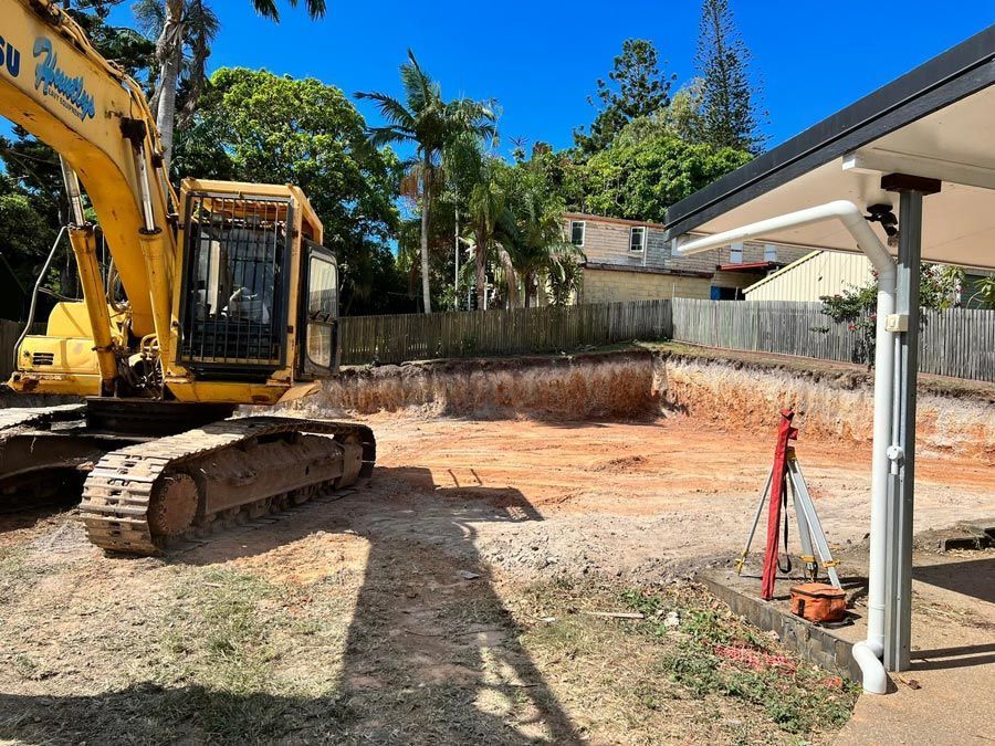 Yellow Excavator in a Construction Site, Digging a Rectangular Hole. Sunny Day — Huntlys Heavy Equipment in Gracemere, QLD