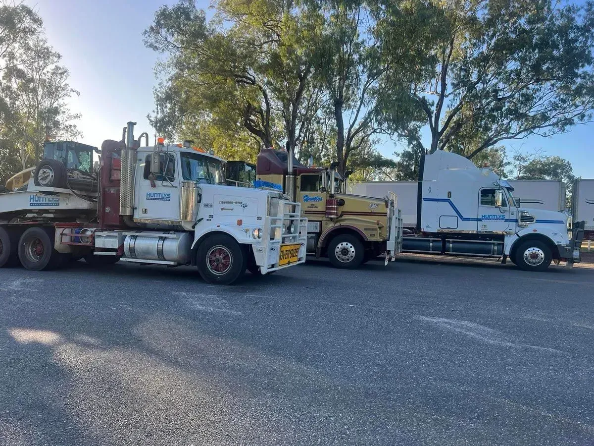 Several Large Trucks Parked Outdoors on a Gravel Lot — Huntlys Heavy Equipment In Gracemere, QLD