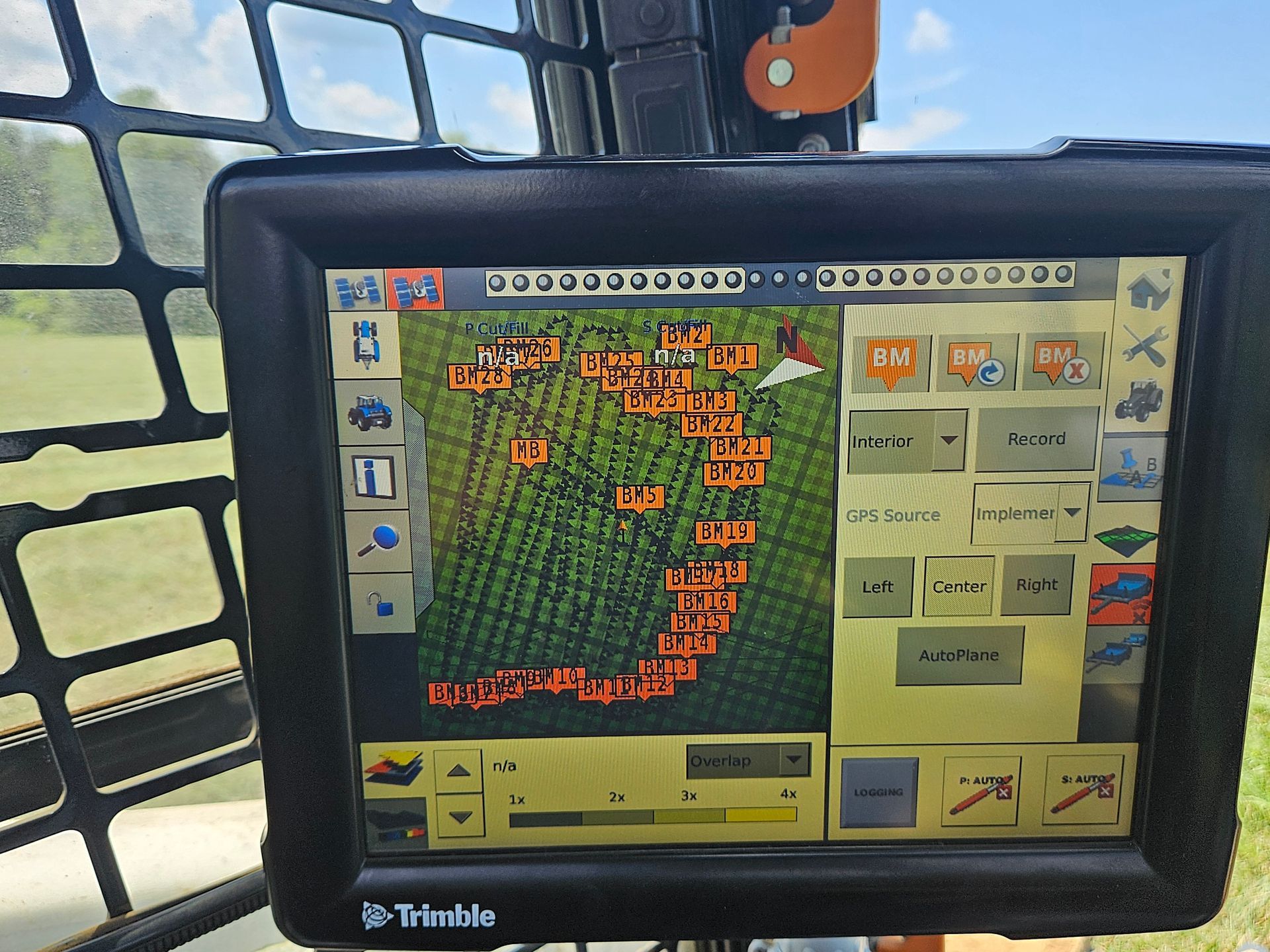 Trimble GPS guidance screen showing a field map with orange path lines and machine controls on a tractor display