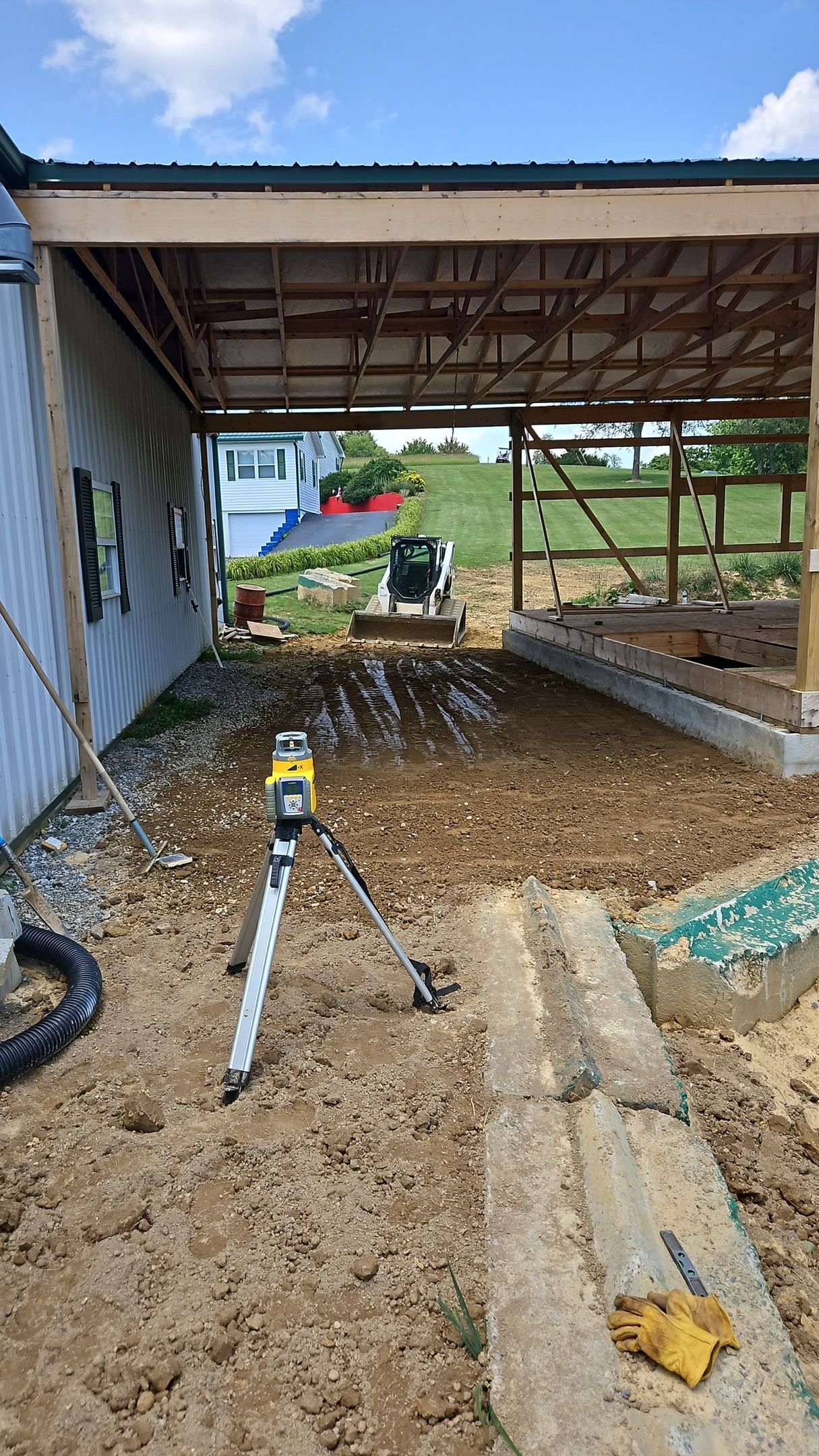 Partially demolished shed interior with muddy ground, exposed beams, and construction debris