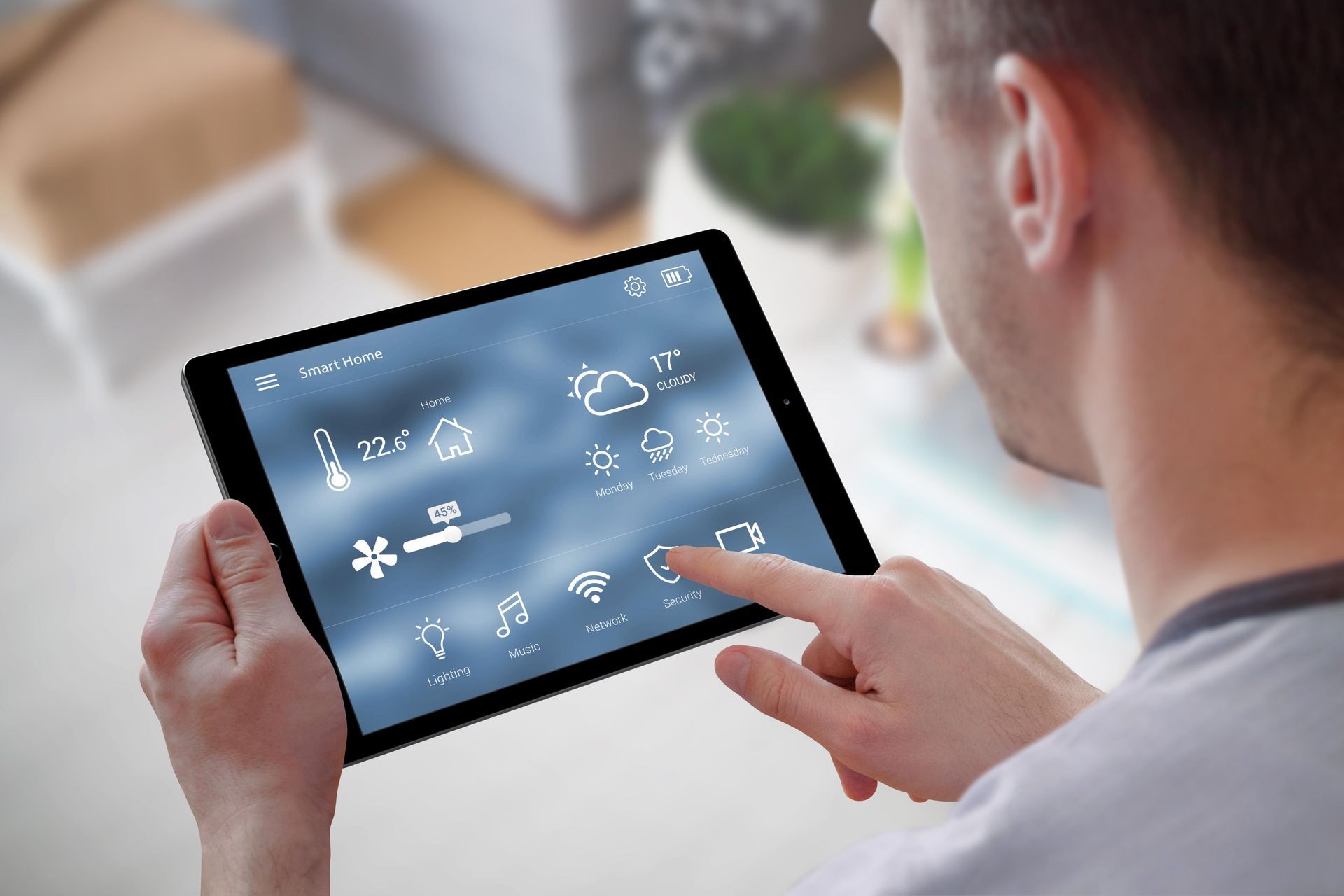 Person using a tablet to view a weather app with forecast icons and temperature charts