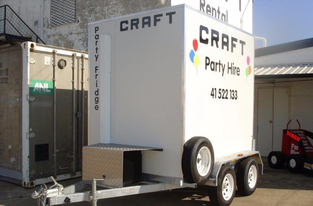 A white refrigerated party hire trailer parked outdoors with 