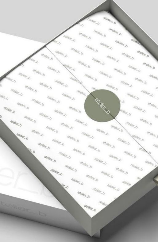 Open white box with patterned interior, sealed with a green circular sticker.