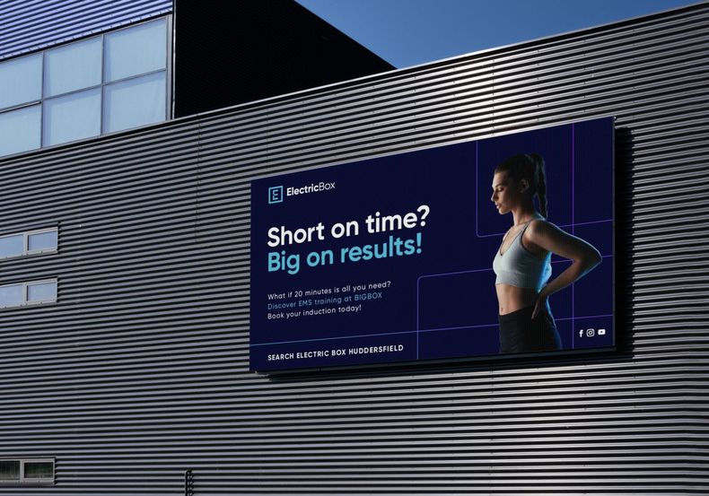 Billboard on a building promoting a fitness program. Woman in workout clothes. Text: 