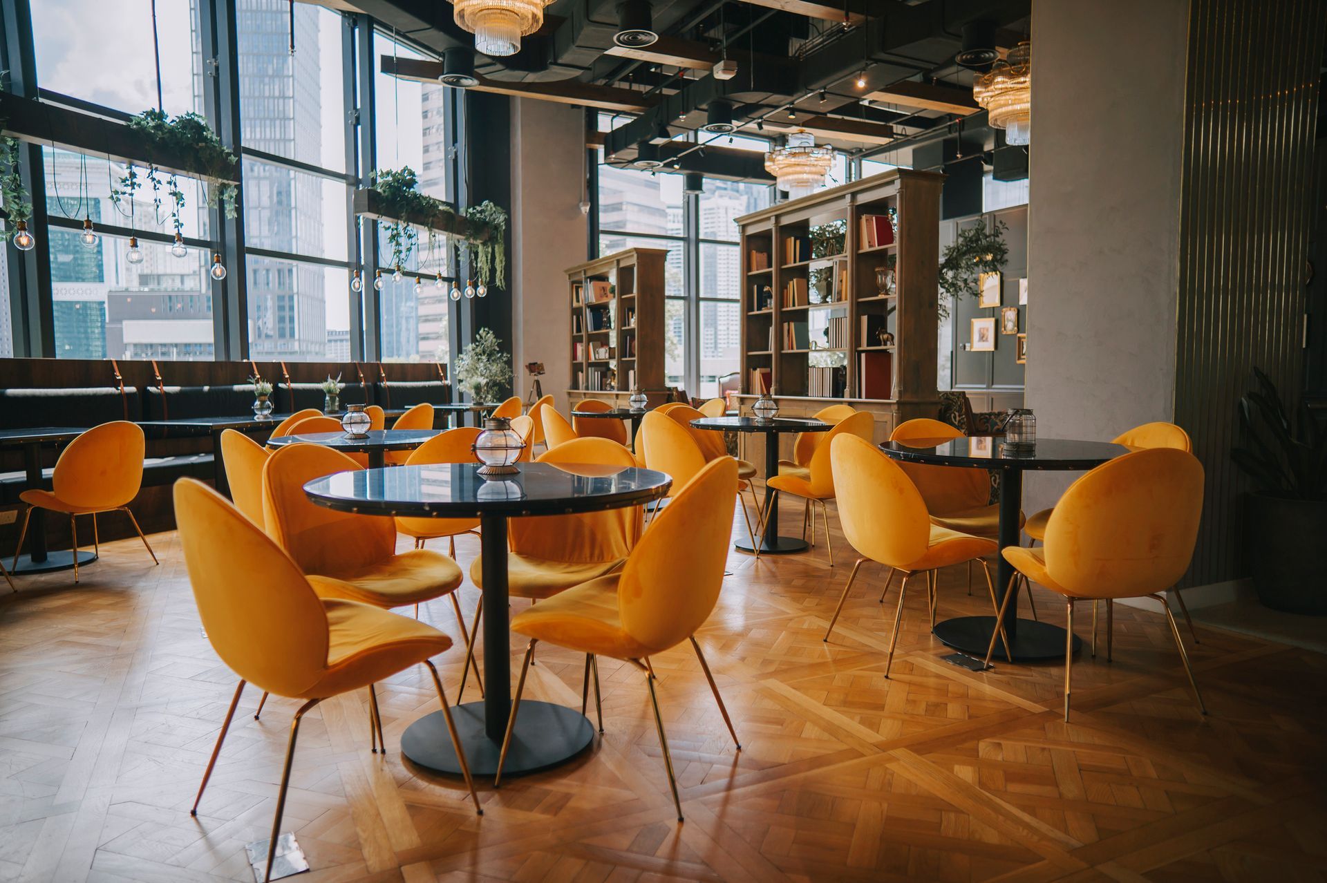 Modern café interior with orange chairs, round tables, and large windows