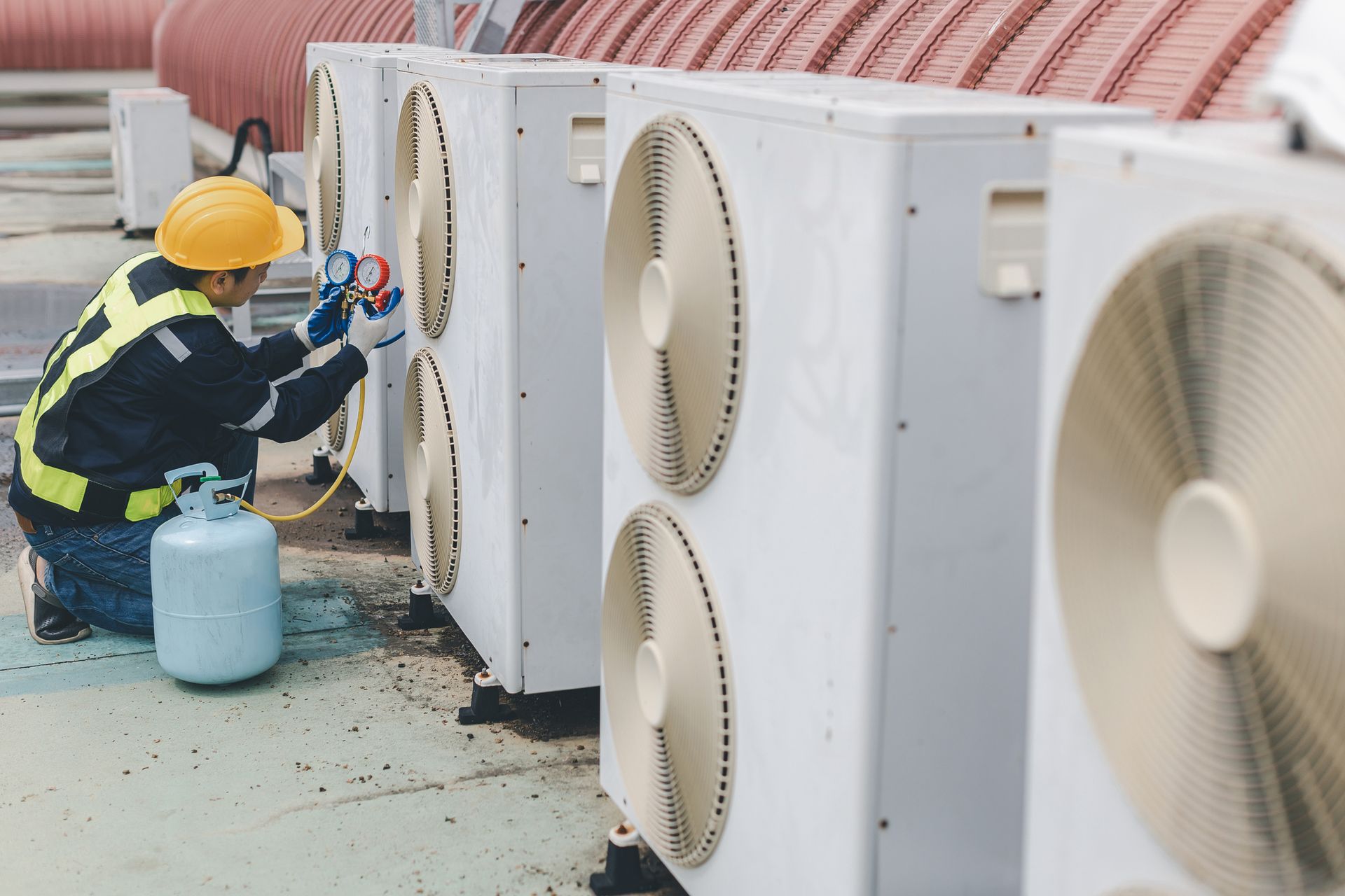 Commercial HVAC technician performs preventative rooftop maintenance on equipment in Philadelphia.