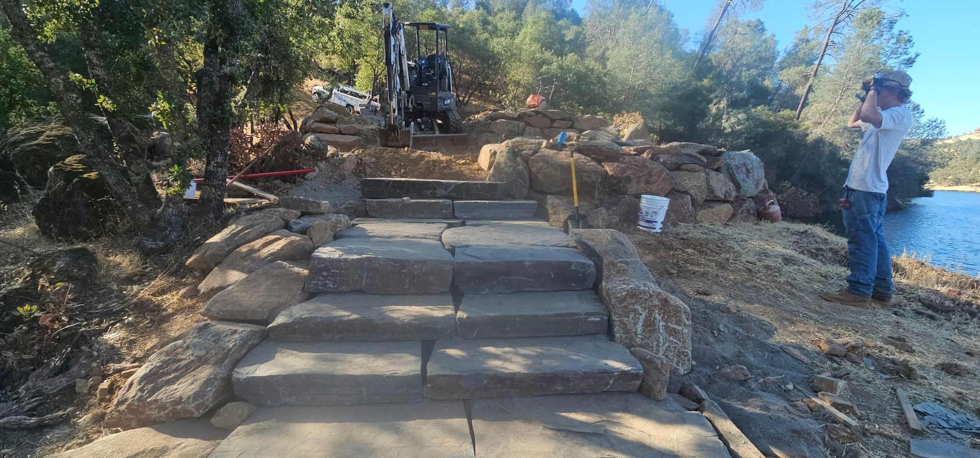 Stone steps leading up a wooded hillside, with two people standing near the path.