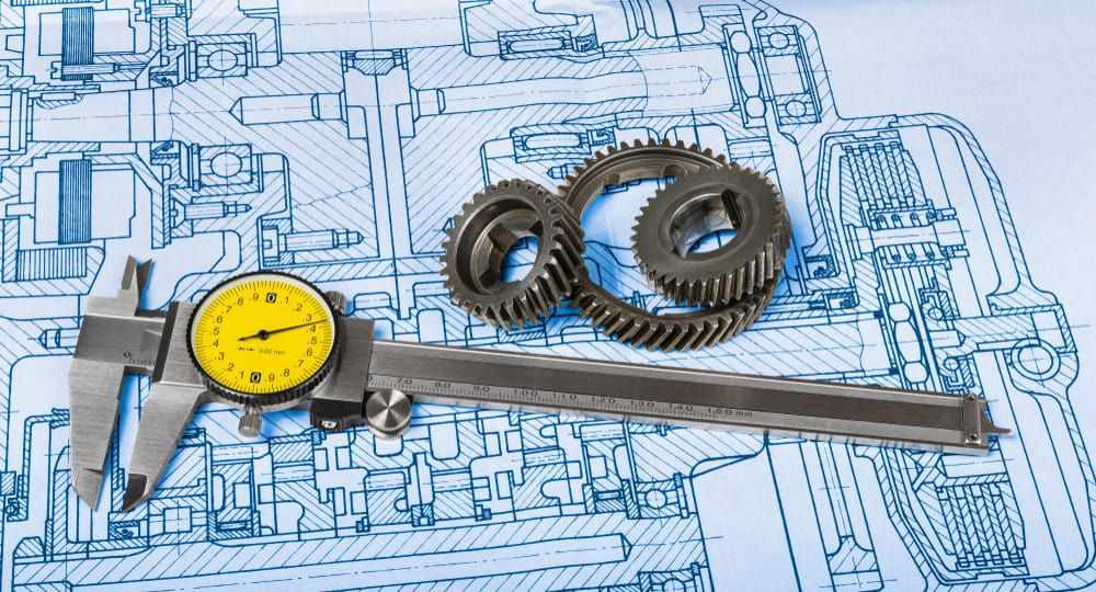 A Caliper and Gears Are Sitting on Top of A Blueprint — Eddies Trailers & Fab in Muswellbrook, NSW