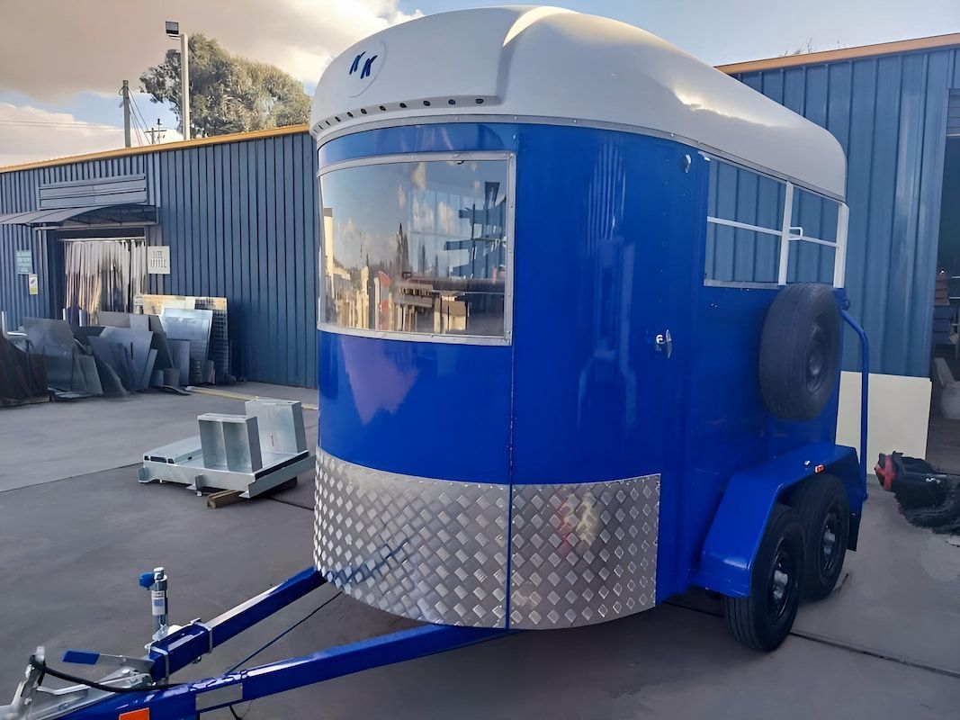 A Blue and White Trailer Is Parked in Front of A Building — Eddies Trailers & Fab in Newcastle, NSW