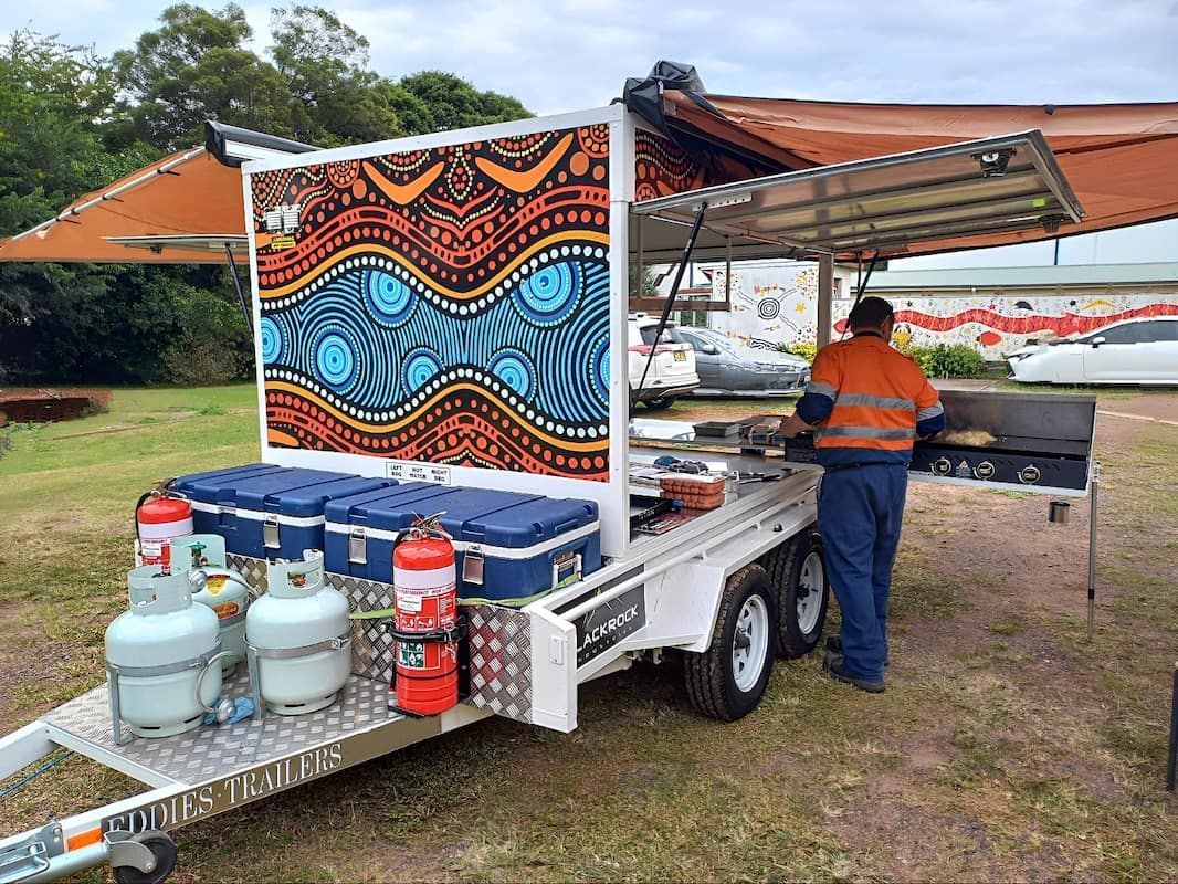 A Man Is Standing in Front of A Trailer with A Painting on It — Eddies Trailers & Fab in Armidale, NSW