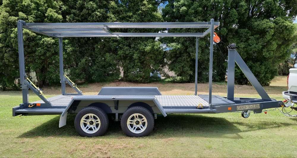 A Trailer Is Parked In A Grassy Field Next To A Truck — Eddies Trailers & Fab in Muswellbrook, NSW