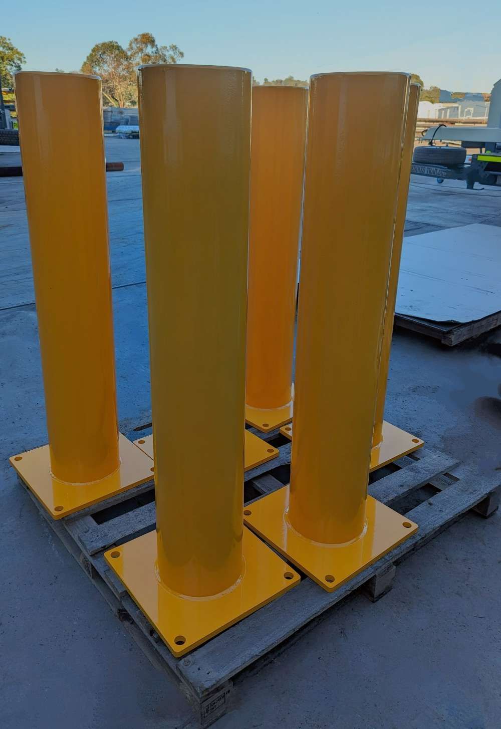 A Group Of Yellow Poles Sitting On Top Of A Wooden Pallet — Eddies Trailers & Fab in Muswellbrook, NSW