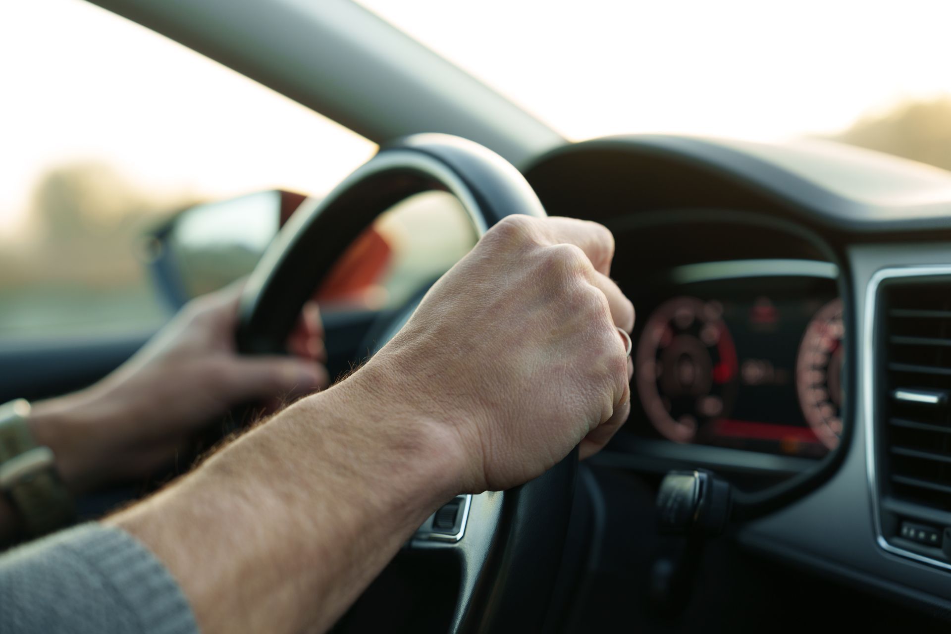 Defensive driving with hands on the steering wheel inside a moving car
