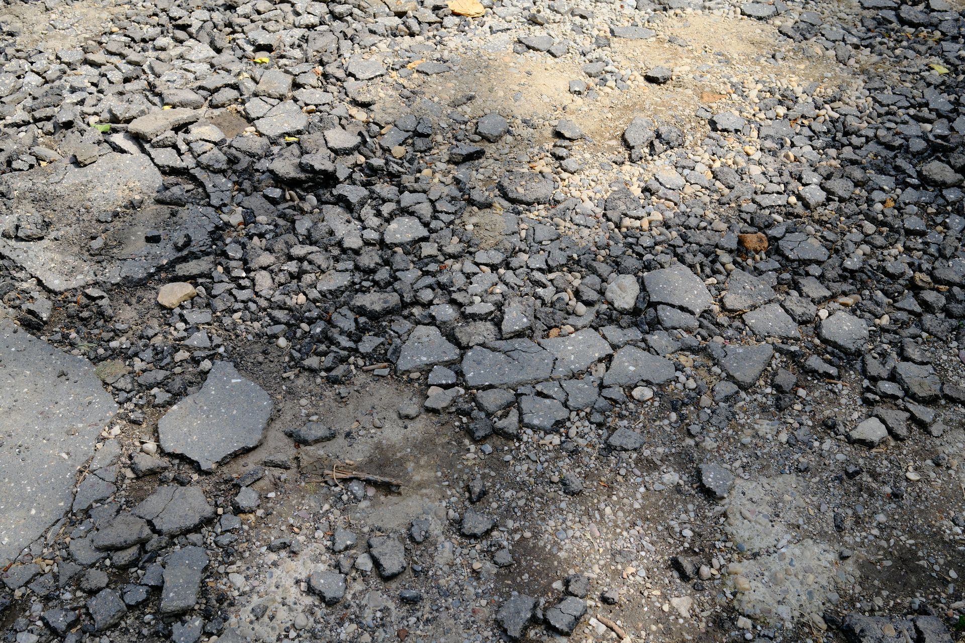 Broken asphalt chunks on a damaged parking lot