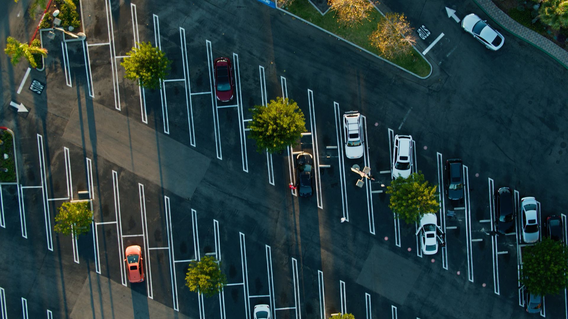 An aerial view of a parking lot with cars parked in rows.