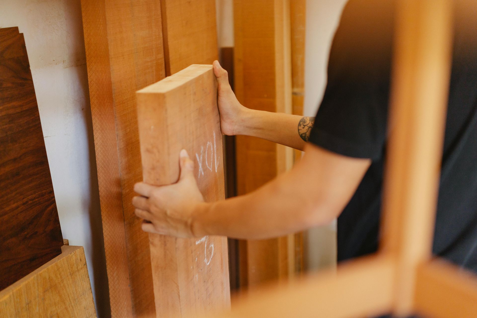 A Person Holds a Thick Board — RAC Carpentry Services in Helensvale, QLD
